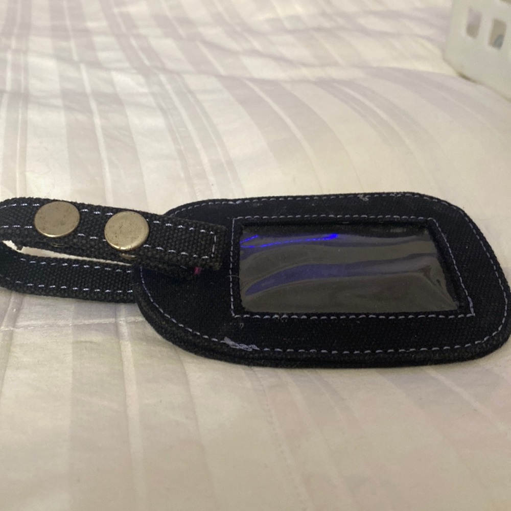 Black luggage tag in great shape a little stain on the back but useful